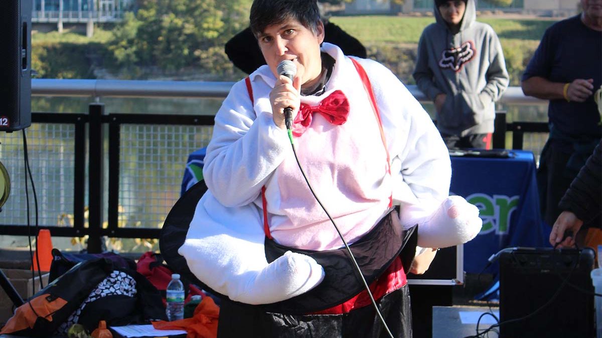 Image of Emmaus resident Cece Wagner in magician's costume, performing magic in front of a crowd.