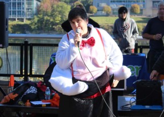 Image of Emmaus resident Cece Wagner in magician's costume, performing magic in front of a crowd.