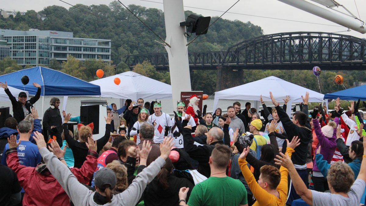 Image of Emmaus Spirit Run participants gathered at the park for a pre-race warm-up.