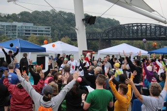 Image of Emmaus Spirit Run participants gathered at the park for a pre-race warm-up.