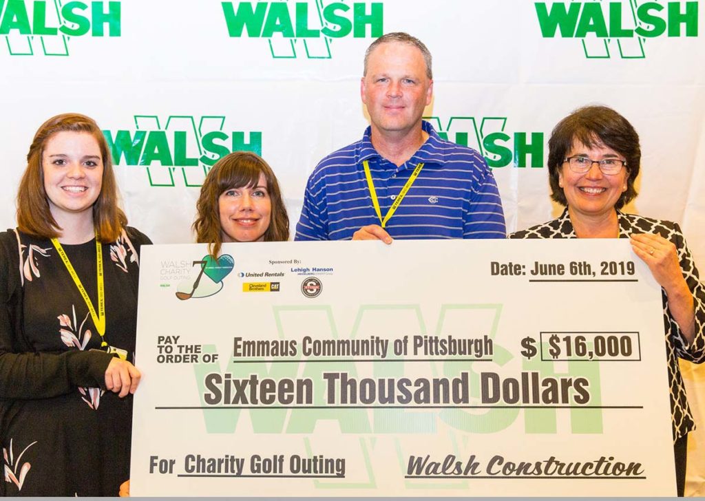 Image of Emmaus staff members and WALSH executive receiving benefit check.