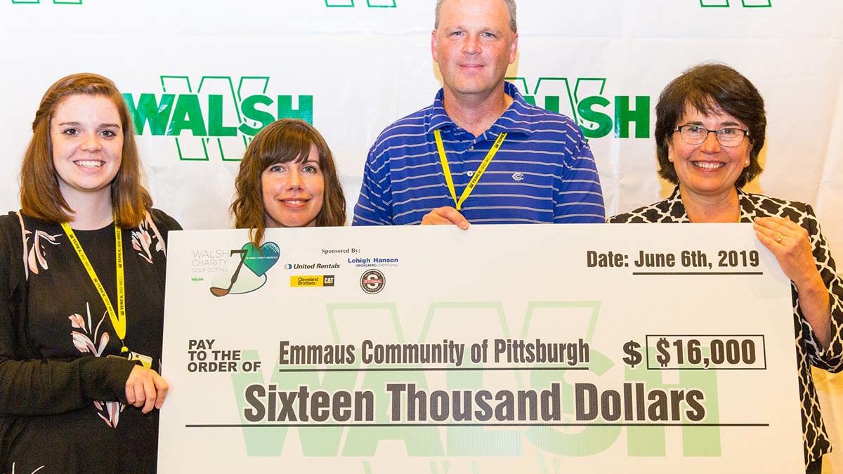 Image of Emmaus staff members and WALSH executive receiving benefit check.