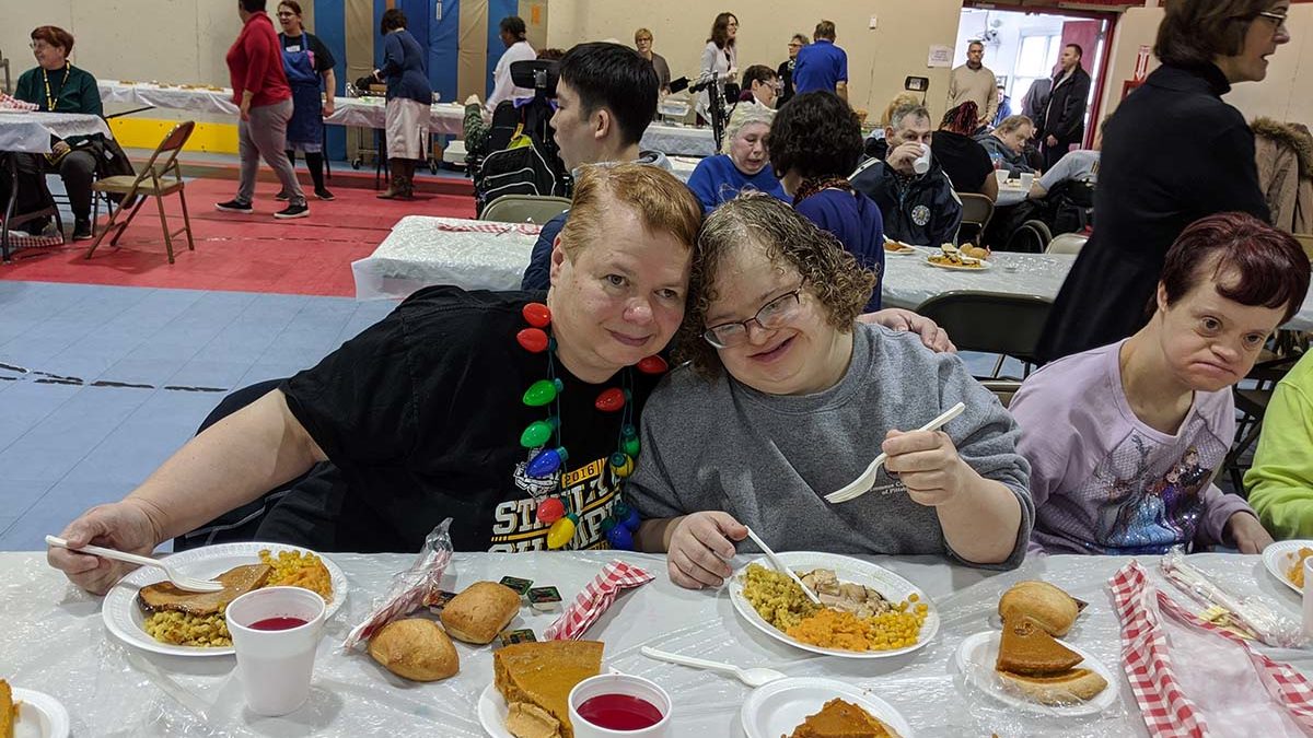 Image of Emmaus residents Amy and Gina at church Thanksgiving feast.