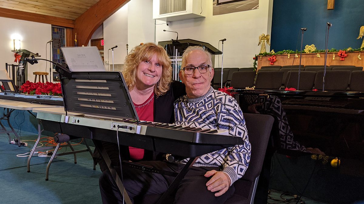 Image of an Emmaus residents and DSP sitting at an instrumental keyboard.