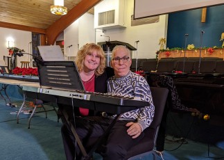 Image of an Emmaus residents and DSP sitting at an instrumental keyboard.
