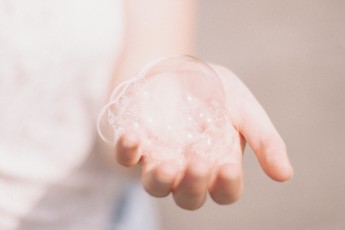 Image of hand holding soap bubbles.